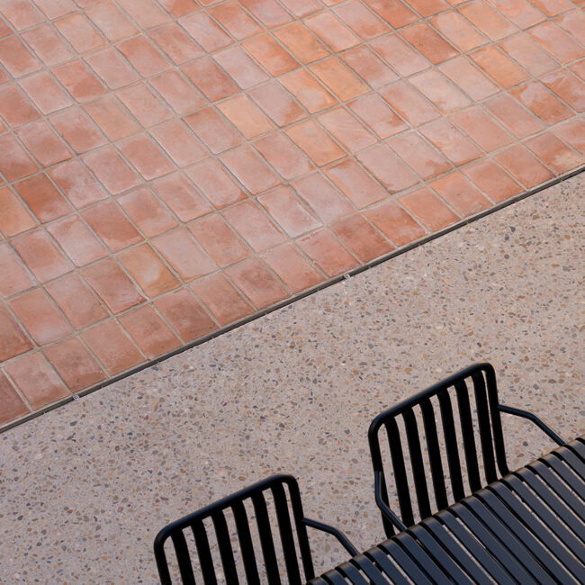 Detalle de pavimentos exteriores en el residencial Living Aviador 47 en Vila-real, Castellón; combinación de barro cocido tradicional y terrazo pulido ejecutado por OCN