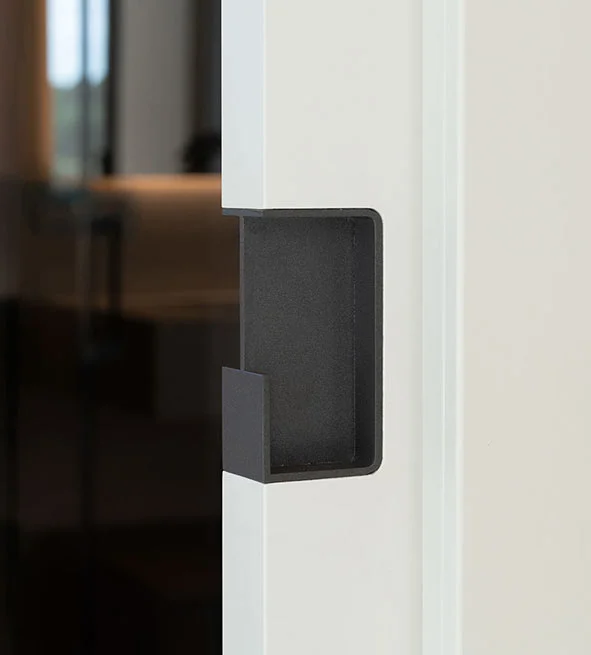 Detalle de tirador integrado negro mate en puerta blanca minimalista, proyecto residencial Maya House en Valencia ejecutado por la empresa constructora OCN