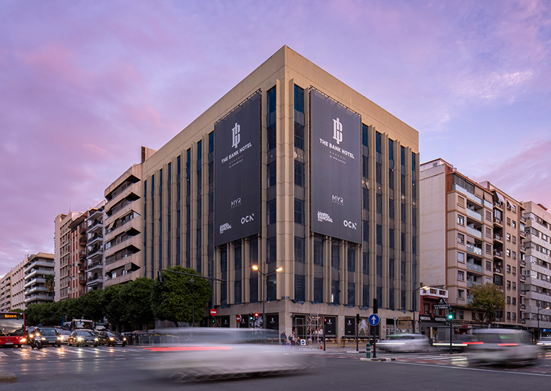 Rehabilitación del edificio The Bank Hotel 5 Estrellas Grand Luxury en Valencia. Fachada histórica restaurada de uso hotelero en esquina estratégica, destacando la arquitectura urbana y lujo en el centro de la ciudad.