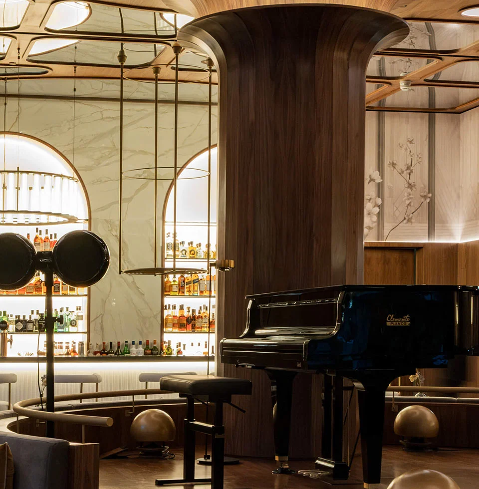 Elegante piano bar con acabados de madera y mármol en el hotel Grand Centenari de Valencia, un proyecto de hospitality ejecutado por la empresa constructora OCN.